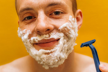 Process of shaving close-up. Young man smiling