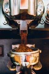 Details of machine pouring and grinding fresh, coffee in local bistro, restaurant or pub