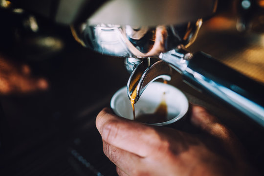 Professional barista man with espresso machine preparing fresh espresso in local pub, bistro or restaurant