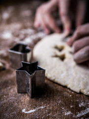 pastry chef hand use cutting mold to cut Cookie dough on kitchen table.