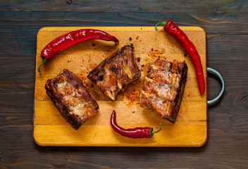 Spicy hot grilled spare ribs from BBQ served  on wooden board . Banner. Top view,  copy space, flat lay.