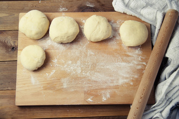 Female Hands Making Dough for baking pie, or pizza. Homemade Preparing Food. Top view. Rustic background.