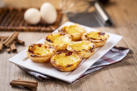 Typical Portuguese custard pies - "Pastel de Nata" or "Pastel de Belem". traditional portuguese pastry. On a wooden table.
