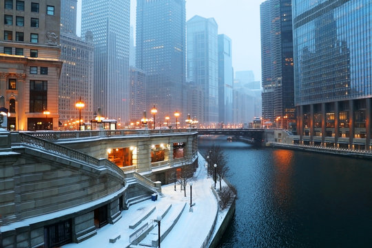 Urban architecture background, big city life concept. Beautiful Chicago downtown cityscape twilight winter view during snowfall. Illinois, Midwest USA.