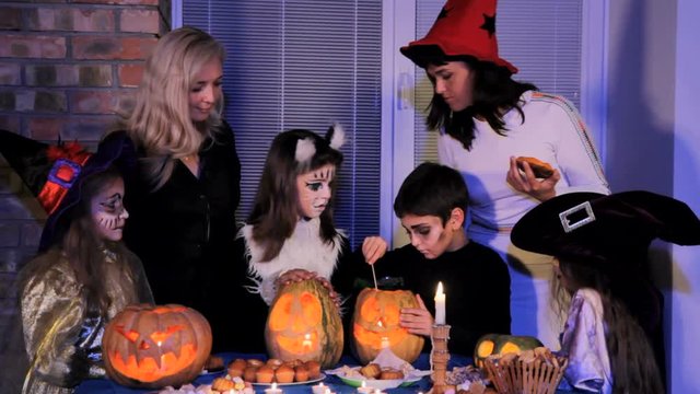 Children and parents near the festive table on Halloween.