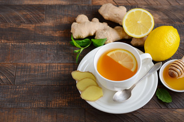 Ginger root tea with lemon and honey on wooden background, selective focus, copy space.