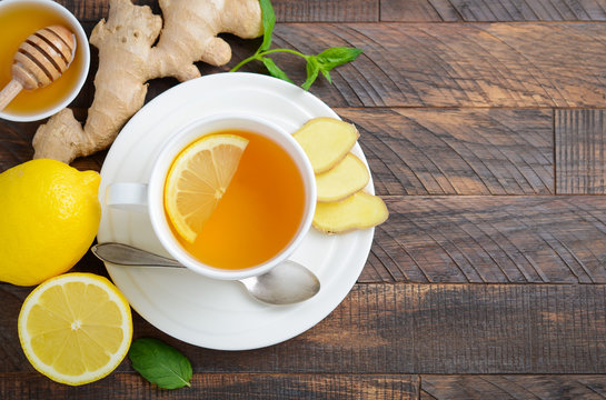 Ginger root tea with lemon and honey on wooden background, top view, copy space.