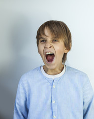 Emotional portrait of irritated shouting teen boy