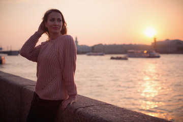 Fototapeta premium Woman walking in the city near river embankment