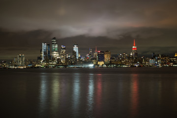 Fototapeta na wymiar Hoboken, New Jersey - September 20 2018 - NYC Skyline with The Empire State Building Lit in Red Color to signify the NY Philharmonic Showcase