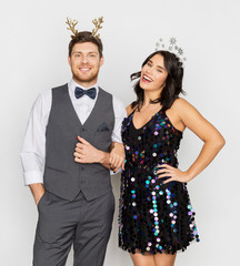 celebration, people and holidays concept - happy couple with christmas or new year party props