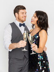 celebration and holidays concept - happy couple with glasses drinking non alcoholic champagne at party
