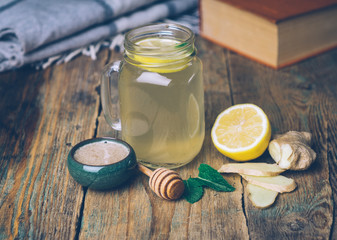 Hot drink with honey, lemon and ginger on wooden background. Concept of natural medicine. Winter or autumn drinks.