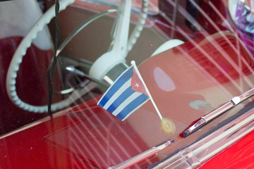 Trinidad, Cuba - Jul 7 2018: Cuban flag inside of old timer car