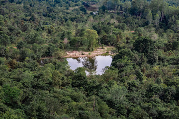 Obraz premium Aerial view of a small lake in the forest surrounding the mountain range at Phu Sing National Park, Bueng Kan, Thailand