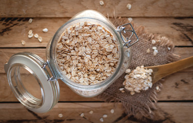 Close-up of oats in a jar, on wooden background, top view