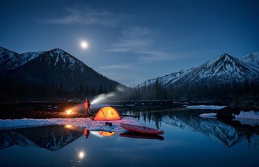 View of camp life in a mountain terrain. Lake shore with canoe - 223774824
