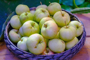 Ripe of green apples in the basket on farmer market.