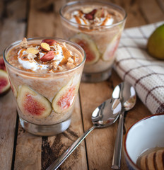 Close-up of oats and chia seeds pudding with figs, on wooden background