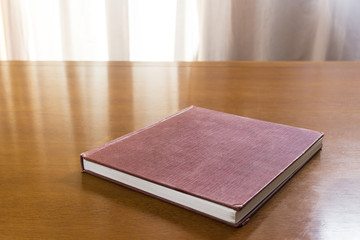 Hard cover books organized over wooden table