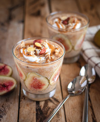Close-up of oats and chia seeds pudding with figs, on wooden background