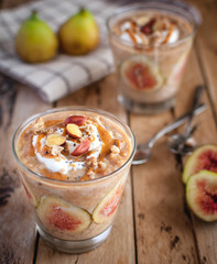 Close-up of oats and chia seeds pudding with figs, on wooden background