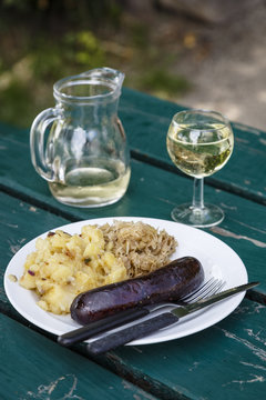 Blood sausage with potatoes and onions with white wine at a traditional restaurant and wine bar in the 19th district, Vienna, Austria.