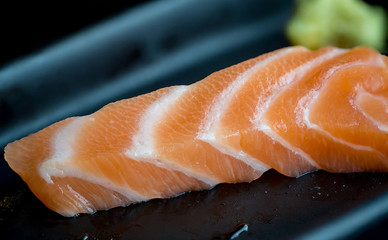 Fresh salmon slice and japanese on dish by lettuce and radish. Clean and fresh food for healthy concept.