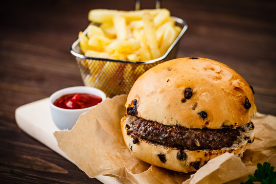 Tasty burger with chips served on cutting board