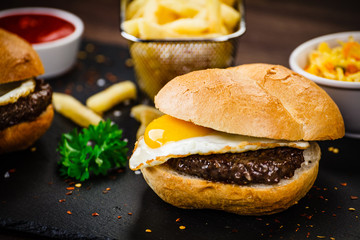Tasty burger with chips served on cutting board
