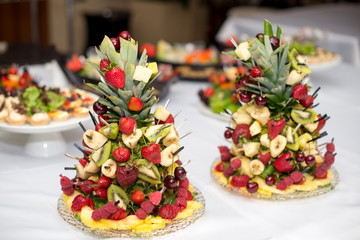 Set of tasty canape, on a plate of greens, tomatoes, peppers, cheese.