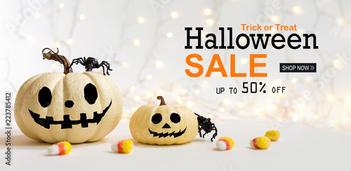 Halloween sale message with pumpkins with spider on a shiny light background