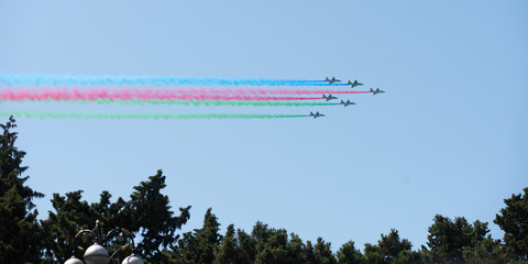 Modern military jet fighter airplanes flying in blue sky. Fighter jets fly together with colorful...