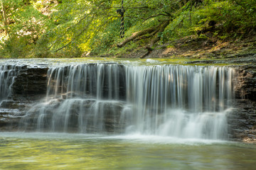 Fototapeta na wymiar Waterfall on small creek in late summer
