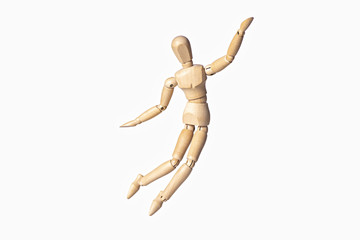 A wooden manikin is happy jumping up and raising it's hand up, isolated on gray background