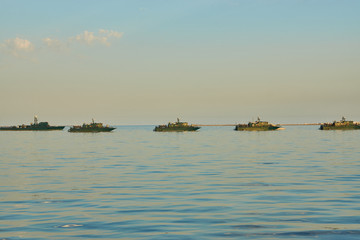 Military Battleships in a sea bay at sunset time. Modern warship sailing in still water. Coast...