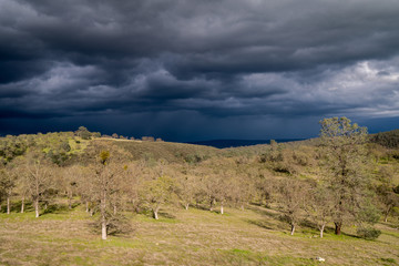 Obraz premium Green hill under dark clouds