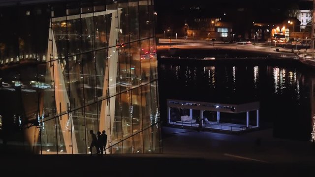 Glass windows in modern building near the lake at night, Norway. 4k