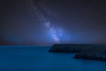 Vibrant Milky Way composite image over landscape of Barafundle Bay on Pembrokeshire Coast in Wales