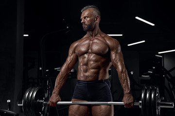Obraz na płótnie Canvas Brutal adult athlete posing in the gym.