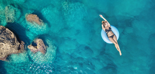 Aerial view at the girl on sea. Turquoise water from air as a background from air. Natural seascape at the summer time. Seascape from drone