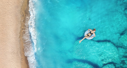 Aerial view at the girl on sea. Turquoise water from air as a background from air. Natural seascape at the summer time. Seascape from drone