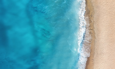 Beach and waves from top view. Turquoise water background from top view. Summer seascape from air....