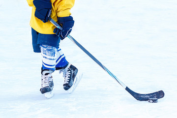 Legs of the hockey player, stick and washer close-up.