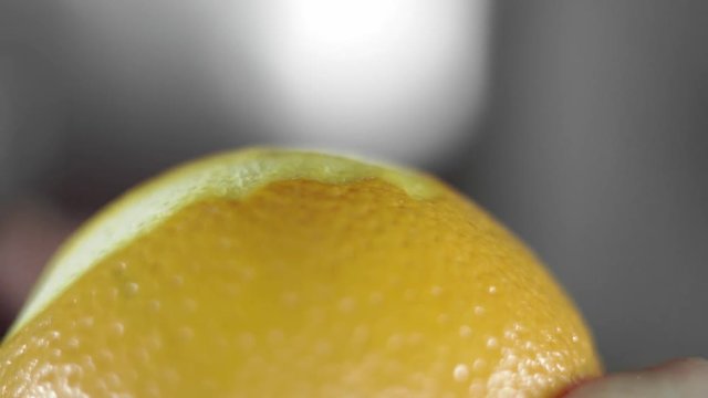 Removing of orange peel from the orange with a knife. Citrus zester grating peeling orange peel, oils spraying.