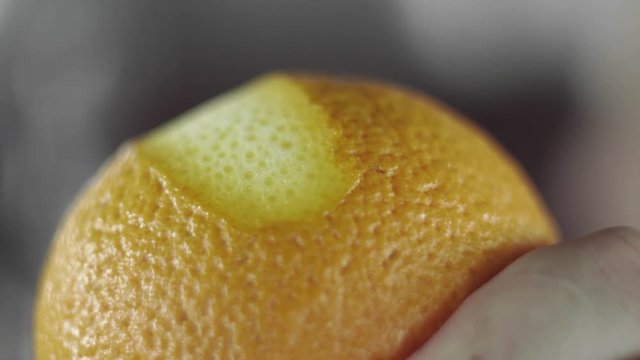 Removing of orange peel from the orange with a knife. Citrus zester grating peeling orange peel, oils spraying.