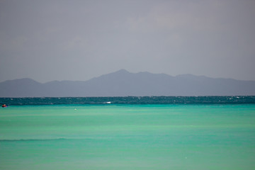 Shallow emerald waters with a mountain on the horizon at Phi Phi Island