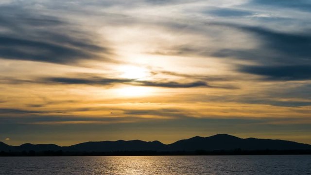 Spectacular sunset mountain and moving clouds over Lake. Time lapse 4k....