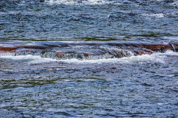 Obraz premium A river gently flowing over rocks