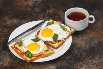 Sandwich with cheese, bacon, tomato and fried egg on plate